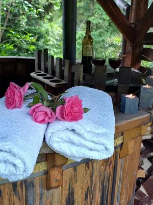 a wooden table with towels and flowers on it at apartament simonka z jacuzzi zawoja in Zawoja