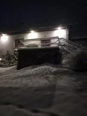 a building with a staircase in the snow at night at apartament simonka z jacuzzi zawoja in Zawoja