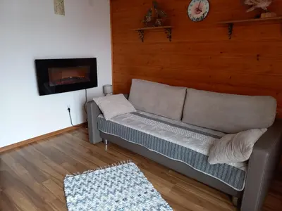 a living room with a couch and a fireplace at apartament simonka z jacuzzi zawoja in Zawoja