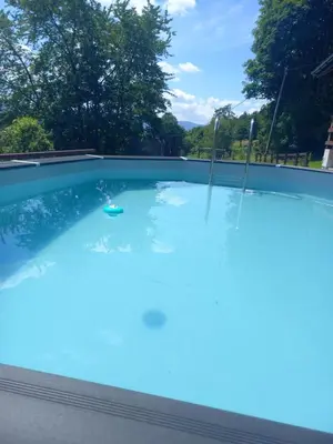 a large swimming pool with blue water at apartament simonka z jacuzzi zawoja in Zawoja