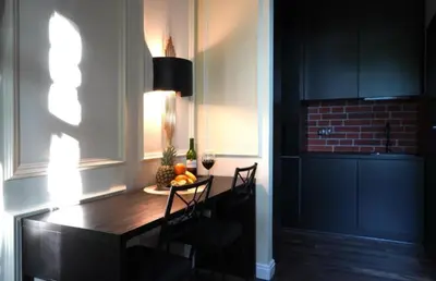 a dining room with a table and chairs and a brick wall at Spa Bath Apartment in Kraków
