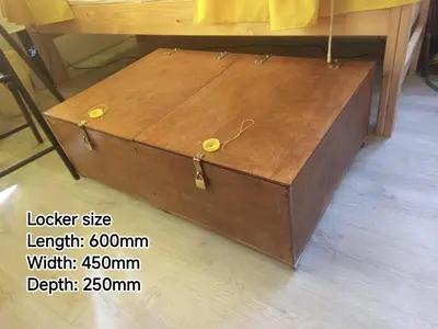a wooden chest sitting on the floor next to a table at Evergreen Hostel Krakow in Kraków