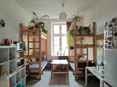 a dorm room with bunk beds and a table at Evergreen Hostel Krakow in Kraków