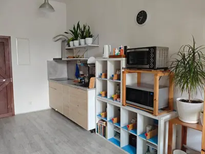 a kitchen with a shelf with a microwave on it at Evergreen Hostel Krakow in Kraków
