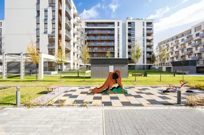 a sculpture of a woman sitting on a checkered sidewalk at Wrocławska Two Bedroom Apartment in Kraków