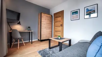 a living room with a couch and a table and a desk at Wrocławska Two Bedroom Apartment in Kraków