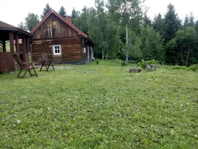 a log cabin in a field of green grass at Stare Sioło in Wysokie