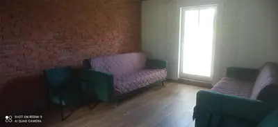 a room with two chairs and a brick wall at Stare Sioło in Wysokie