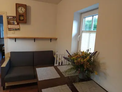 a living room with a couch and a table and a clock at Stare Sioło in Wysokie