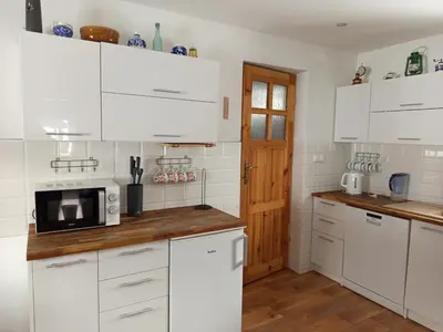 a kitchen with white cabinets and a microwave at Stare Sioło in Wysokie