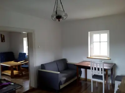 a living room with a couch and a table and a window at Stare Sioło in Wysokie