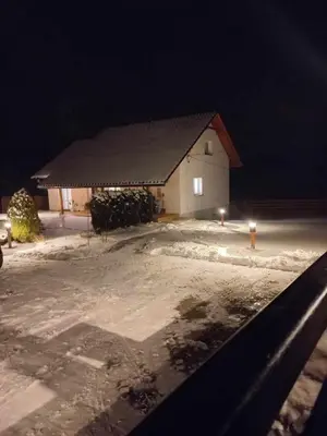 a building at night with snow in front of it at Dom Pod Gaikiem in Łękawica