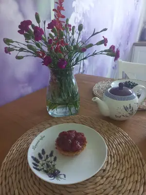 a plate with a pastry on a table with a vase with flowers at Dom Pod Gaikiem in Łękawica