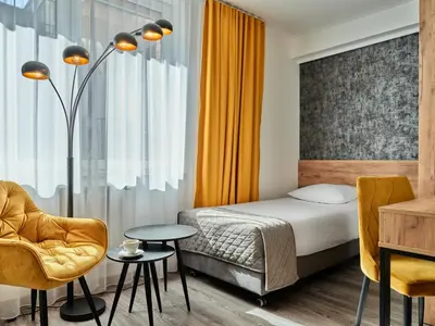 a hotel room with a bed and a table and chairs at 1891 Garni Hotel in Kraków