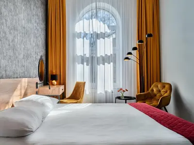 a bedroom with a bed and a large window at 1891 Garni Hotel in Kraków