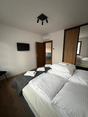 a bedroom with two beds with white sheets at Domki nad Stawami in Ujanowice