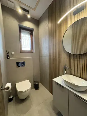 a bathroom with a toilet and a sink and a mirror at Domki nad Stawami in Ujanowice