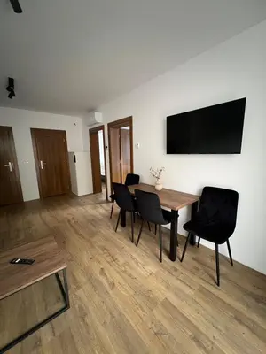 a room with a table and chairs and a flat screen tv at Domki nad Stawami in Ujanowice