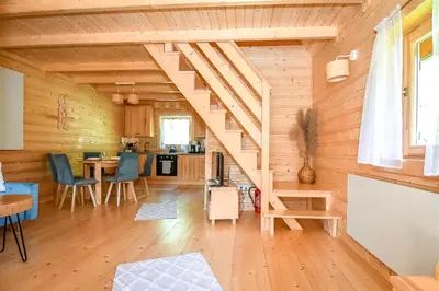 a living room with a staircase in a log cabin at Domek na Groniku in Zubrzyca Górna