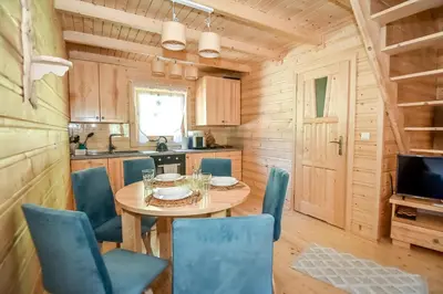 a kitchen and dining room with a table and chairs at Domek na Groniku in Zubrzyca Górna