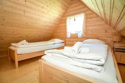 a bedroom with two beds in a log cabin at Domek na Groniku in Zubrzyca Górna