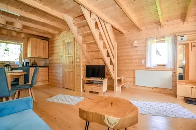a log cabin living room with a table and a tv at Domek na Groniku in Zubrzyca Górna