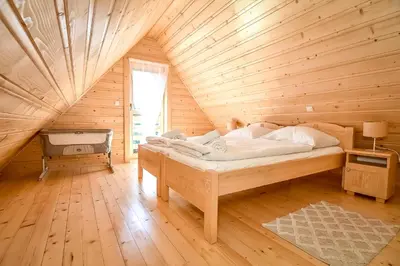 a bedroom with a bed in a wooden cabin at Domek na Groniku in Zubrzyca Górna