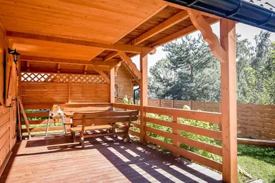 a wooden deck with a table and a bench on it at Domek na Groniku in Zubrzyca Górna