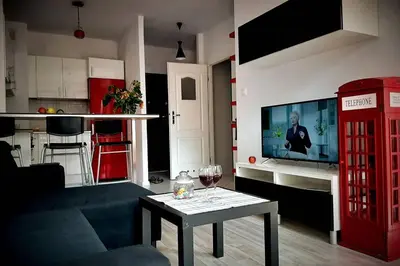 a living room with a red phone booth and a table at Apartament z tarasem - Appartment with tarace in Kraków