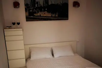 a bedroom with a bed with two glasses of wine at Apartament z tarasem - Appartment with tarace in Kraków