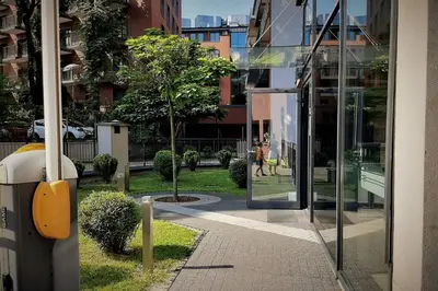 a woman walking down a sidewalk in front of a building at Apartament z tarasem - Appartment with tarace in Kraków