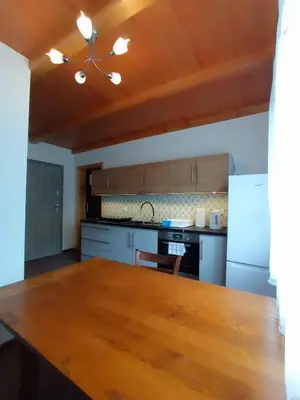 a kitchen with a wooden table in a room at Noclegi Leśniczówka w Lanckoronie in Lanckorona