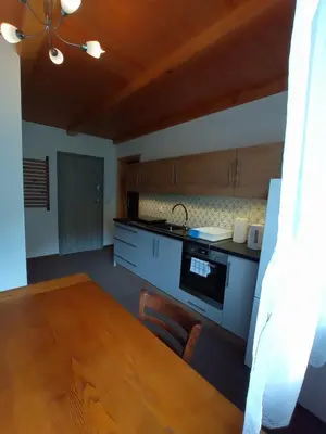 a kitchen with a wooden table and a dining room at Noclegi Leśniczówka w Lanckoronie in Lanckorona