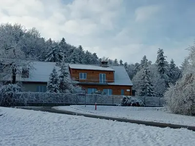 a wooden house in the snow with trees at Noclegi Leśniczówka w Lanckoronie in Lanckorona