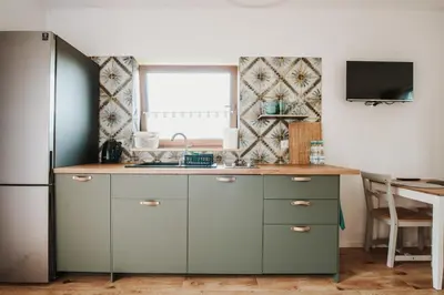 a kitchen with a sink and a refrigerator at Rogate Domki in Zasań
