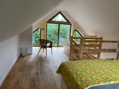 a bedroom with a bed and a bathroom with a tub at Rogate Domki in Zasań