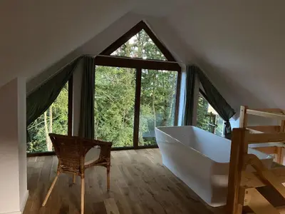 a bathroom with a large window and a bath tub at Rogate Domki in Zasań
