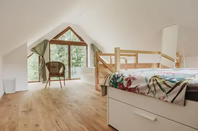 a bedroom with a bed and a desk and a chair at Rogate Domki in Zasań