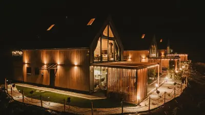 a building with lights on it at night at Osada Mosorny Groń - Zawoja in Zawoja