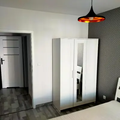 a room with a white cabinet and a mirror at APARTAMENT HELSINKI in Kraków