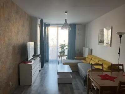 a living room with a yellow couch and a table at APARTAMENT HELSINKI in Kraków