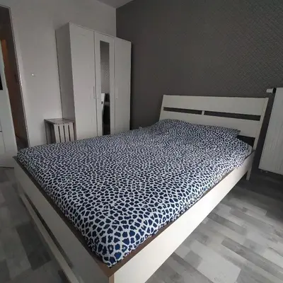 a bedroom with a bed with a black and white comforter at APARTAMENT HELSINKI in Kraków