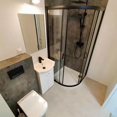 a bathroom with a shower and a toilet and a sink at APARTAMENT HELSINKI in Kraków