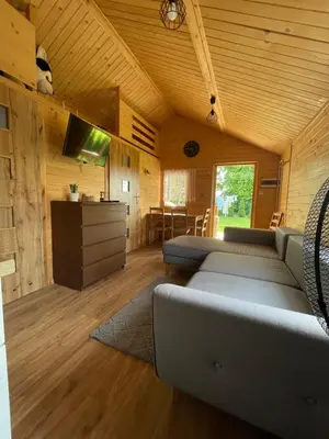 a living room with couches and a television in a cabin at Chatka pod orzechem in Spytkowice