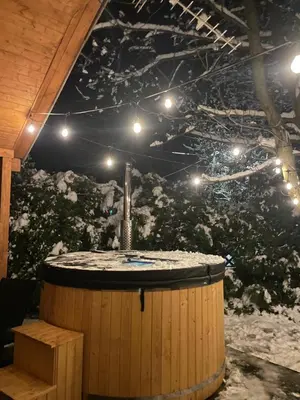 a large hot tub on a deck with a roof at Chatka pod orzechem in Spytkowice
