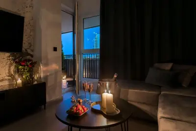 a living room with a table with candles and a couch at Barska 69 Apartments in Kraków