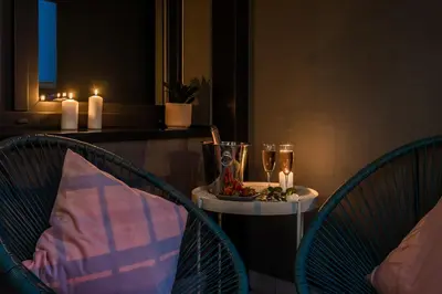 a table with two chairs and two glasses and candles at Barska 69 Apartments in Kraków