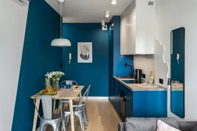 a kitchen with blue walls and a table with chairs at Barska 69 Apartments in Kraków
