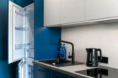 a kitchen with a sink and a refrigerator at Barska 69 Apartments in Kraków