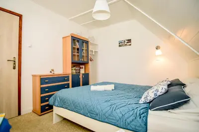 a bedroom with a blue bed and a blue dresser at Apartament w Alejce in Rabka